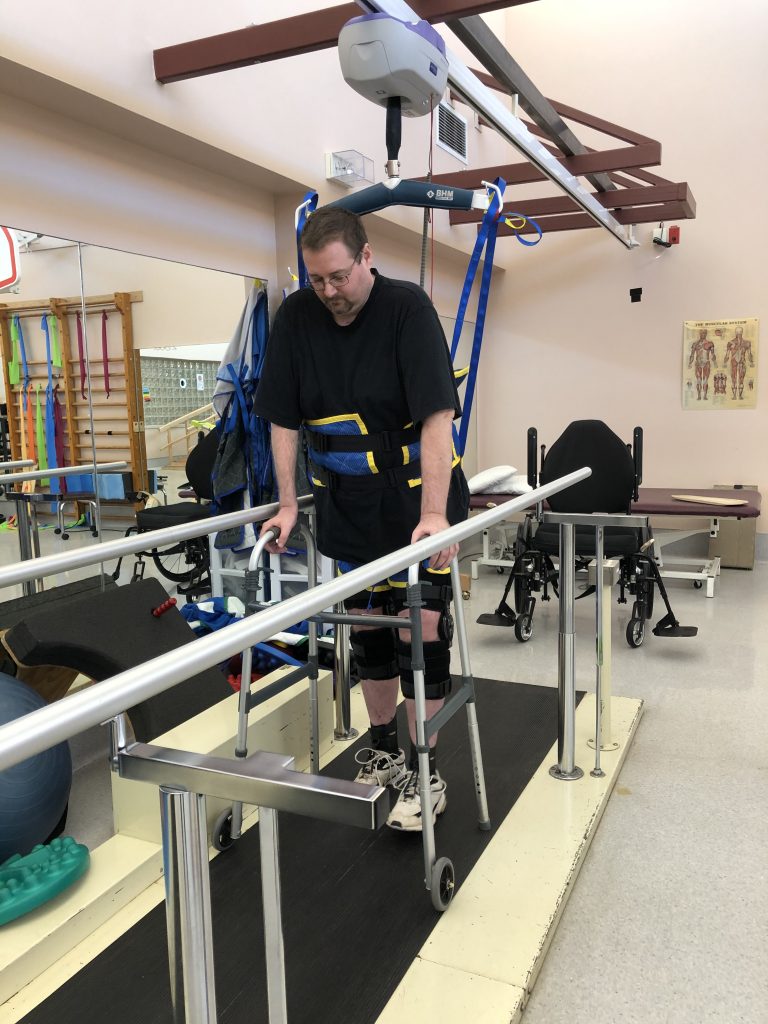 DonJoy Knee Braces & Walking With Walker Between Parallel Bars in Physiotherapy at The Stan Cassidy Rehabilitation Centre in Fredericton - Jamie Boyle Guillain Barre Syndrome - GBS Recovery